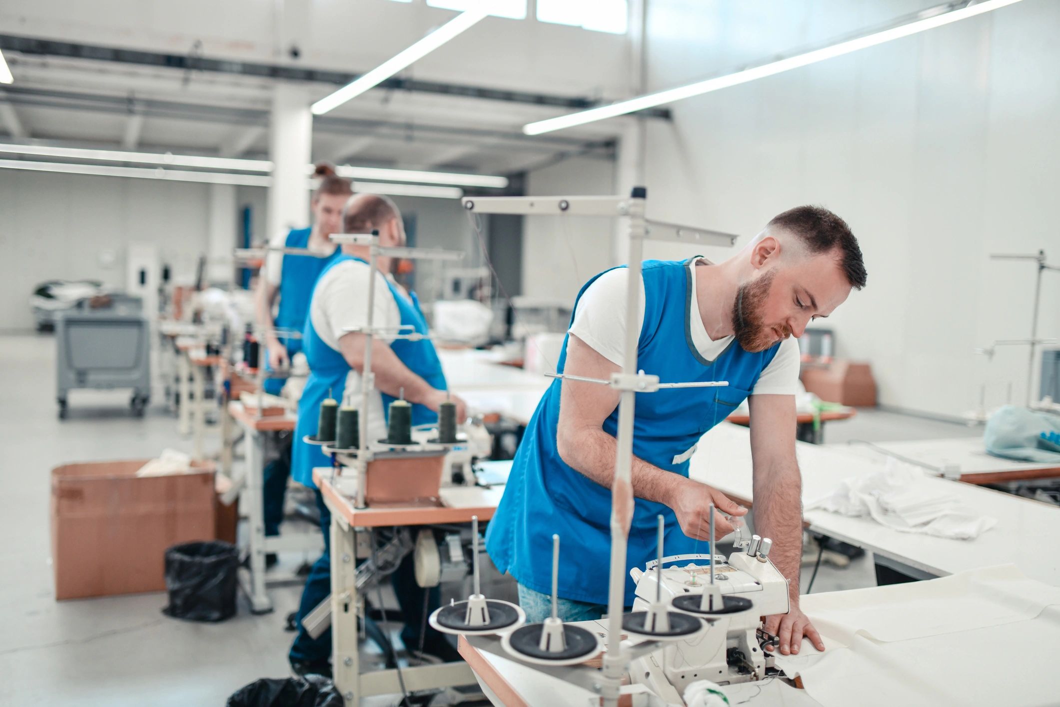 Textile workers sewing materials on machines
