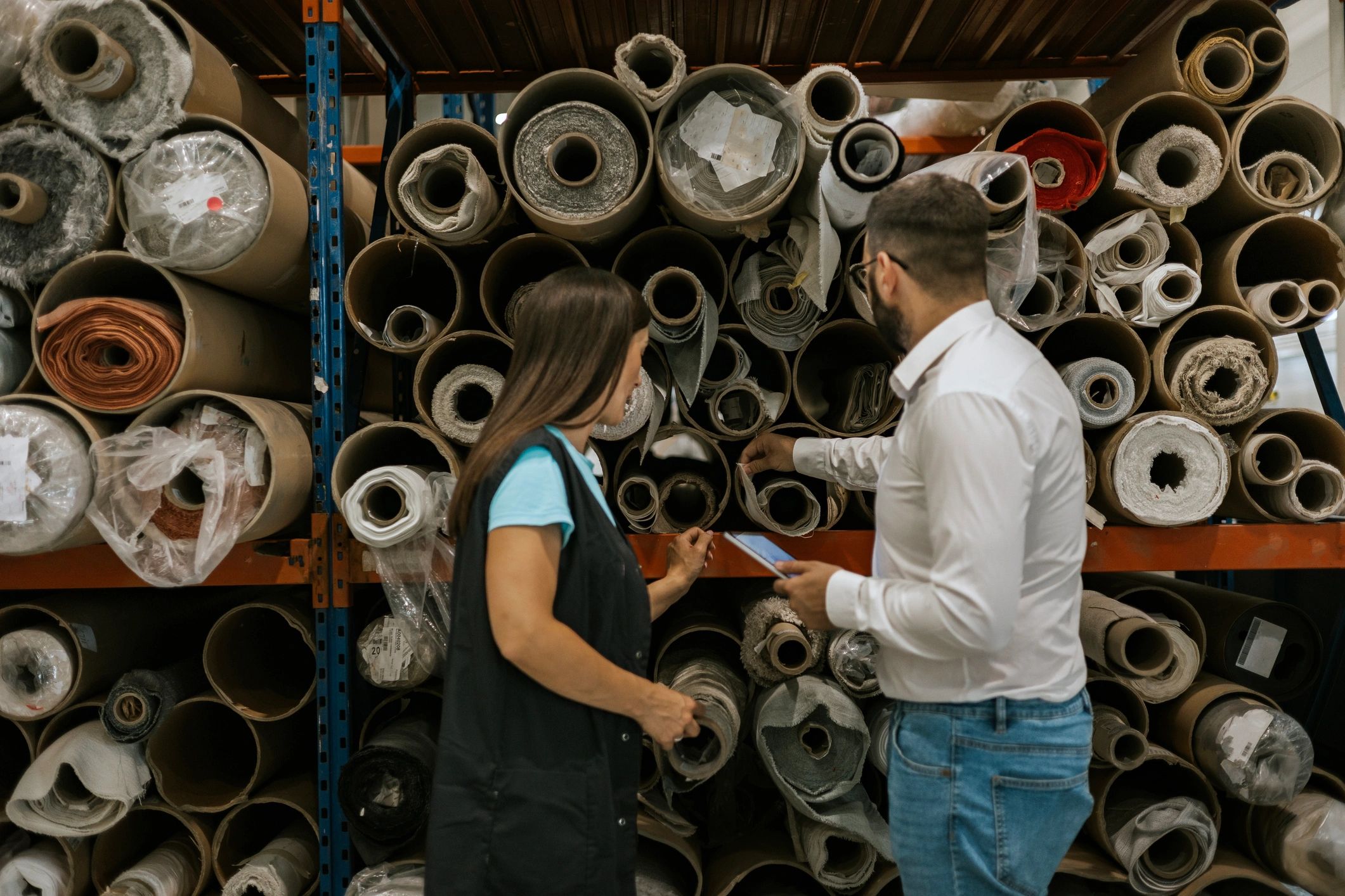 Textile plant workers inspecting fabric rolls for quality