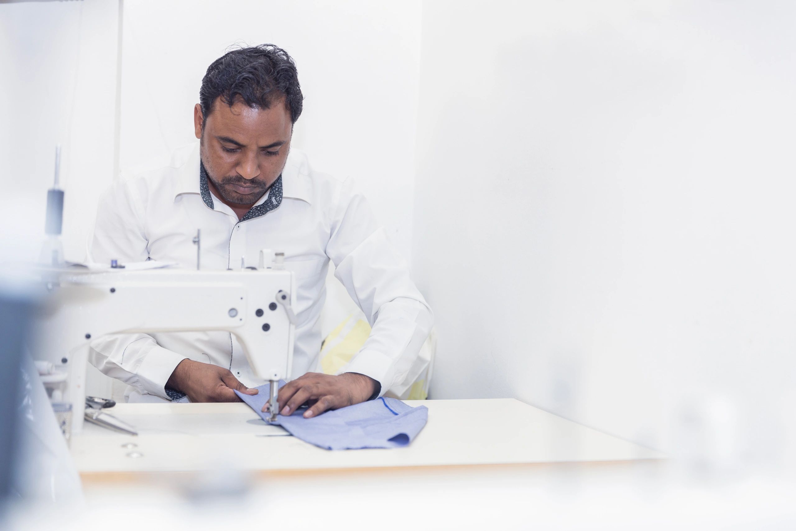 Tailor using a sewing machine in a garment workshop