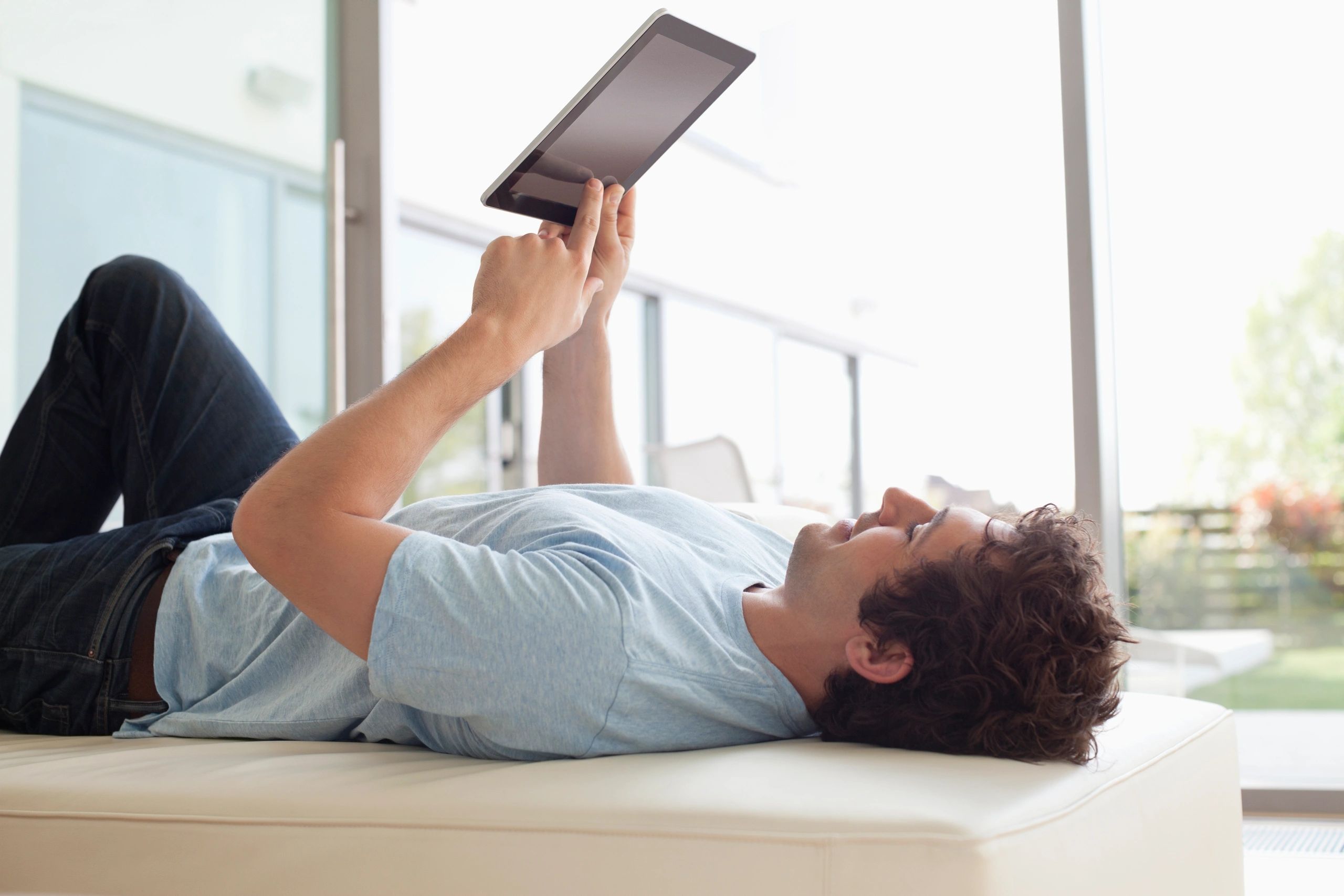 Person relaxing while using a tablet for digital reading